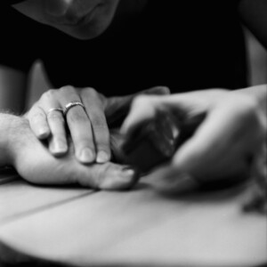 Frau lackiert eine Männerhand