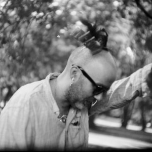 Mann pinkelt an einen Baum